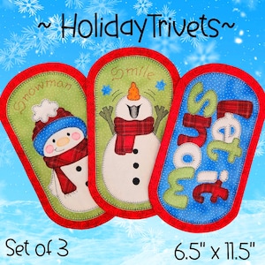 May include: Set of three holiday trivets with snowman designs. Each trivet is approximately 6.5 inches by 11.5 inches. The trivets feature a red border and include the words "Snowman", "Smile", and "Let it Snow".
