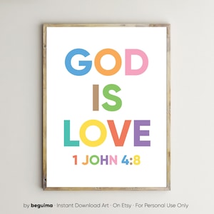 May include: A framed print with the words "GOD IS LOVE" in large, colorful letters. The text "1 JOHN 4:8" is at the bottom. The frame is a light brown color, and the background is white.