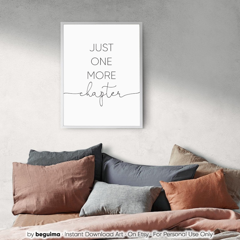 Peut inclure: Une impression encadr&eacute;e blanche avec du texte noir qui dit "JUST ONE MORE chapter" dans une police cursive. L'impression est accroch&eacute;e &agrave; un mur au-dessus d'un lit avec des oreillers.