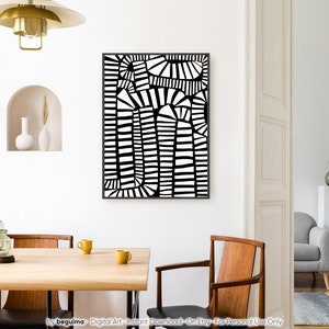 May include: Abstract black and white art print in a black frame. The artwork has a geometric design with curved and straight lines. The print is displayed on a white wall in a dining room setting.