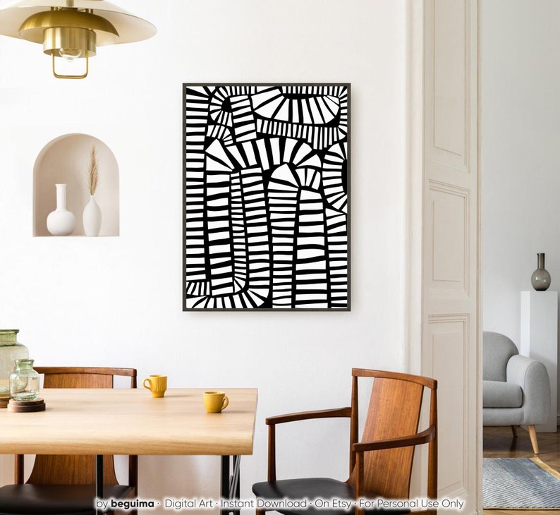 May include: Abstract black and white art print in a black frame. The artwork has a geometric design with curved and straight lines. The print is displayed on a white wall in a dining room setting.