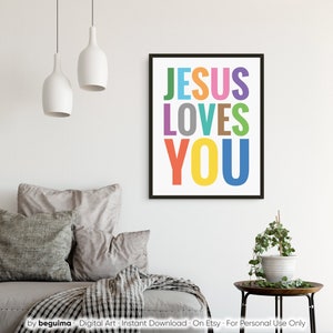 Może przedstawiać: Cyfrowy wydruk artystyczny z tekstem "JESUS LOVES YOU" w kolorowych literach. Wydruk jest oprawiony w czarną ramkę i ma białe tło.