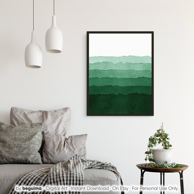 May include: A framed watercolor print featuring horizontal bands of varying shades of green, from light to dark. The artwork has a minimalist style and is displayed in a room with neutral-toned furniture and decor.