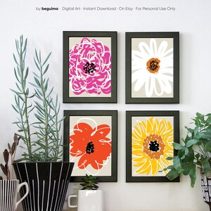 May include: Four framed floral art prints. Each print features a different abstract flower design in vibrant colors: pink, white, orange, and yellow. The prints are set against a neutral background and framed in black.