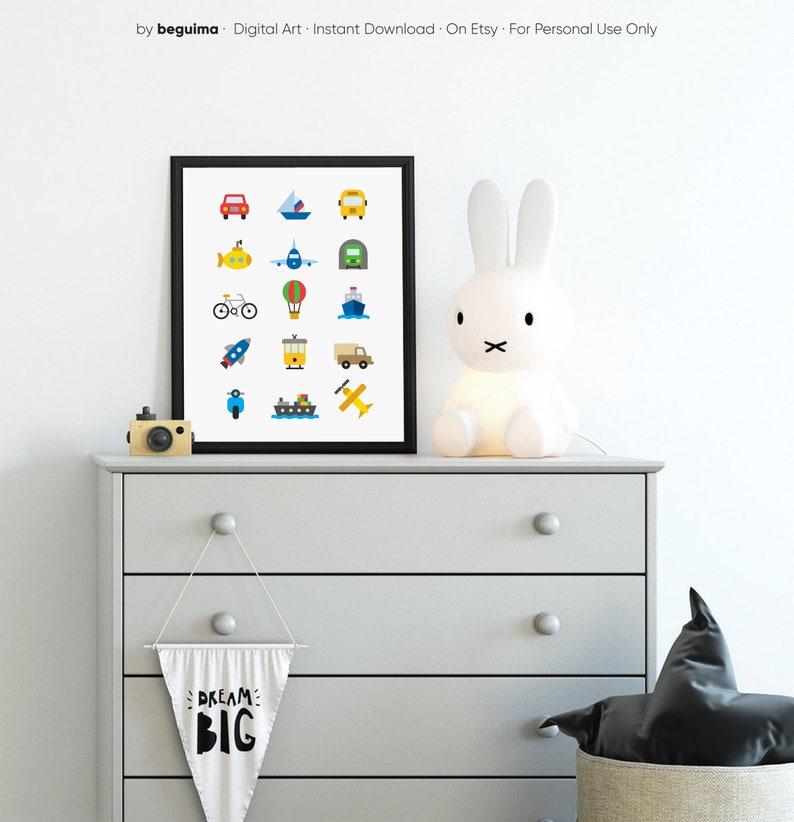 May include: A framed print featuring colorful illustrations of various vehicles, including a car, boat, bus, submarine, airplane, hot air balloon, rocket, train, truck, scooter, ship, and airplane. The print is displayed on a gray dresser with a bunny lamp and a banner that says "DREAM BIG".