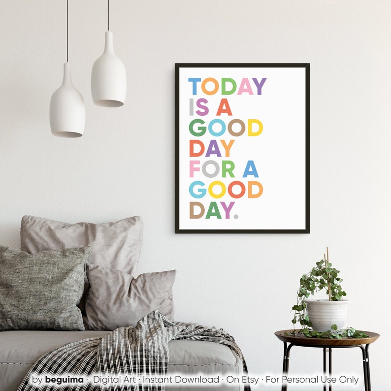 May include: A colorful typography print with the text "TODAY IS A GOOD DAY FOR A GOOD DAY." The print is framed in a black frame and is hanging on a white wall.