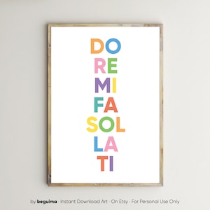 May include: A framed art print featuring the musical notes DO, RE, MI, FA, SOL, LA, TI in a vertical arrangement. Each note is a different color: blue, purple, green, orange, yellow, pink, and red. The print is on a white background.