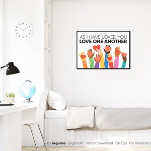 May include: A digital art print with a white background and colorful hands holding red hearts. The text "John 13:34 AS I HAVE LOVED YOU LOVE ONE ANOTHER" is printed in black.