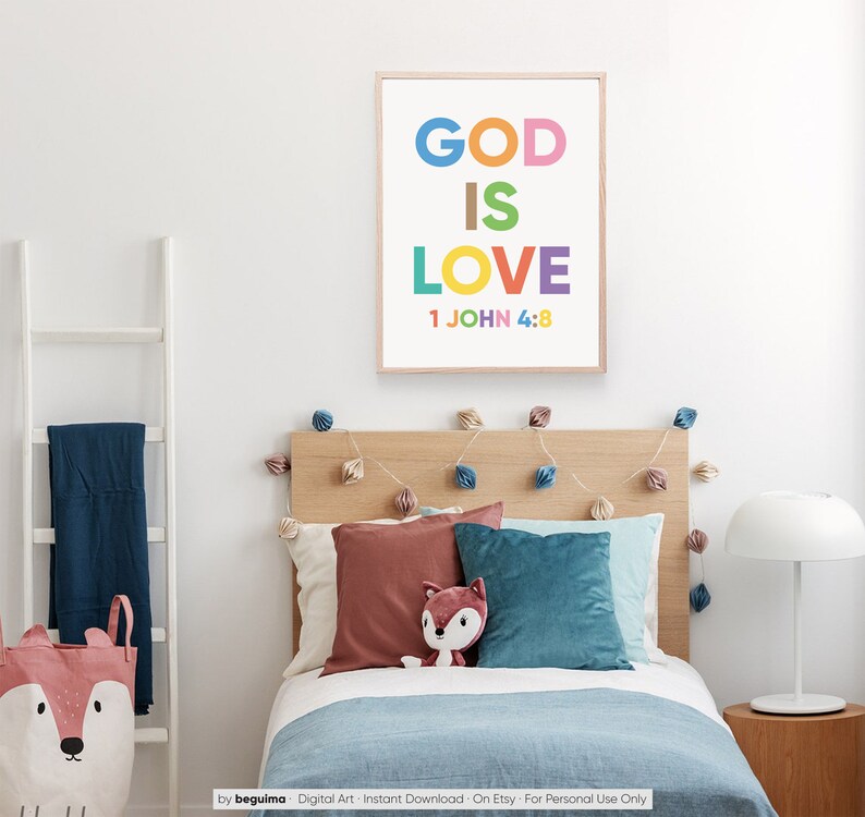May include: A framed print with the words "GOD IS LOVE" in colorful letters, with "1 JOHN 4:8" below. The print hangs above a bed with pillows and a stuffed fox. A white ladder and a fox-themed storage basket are also visible.