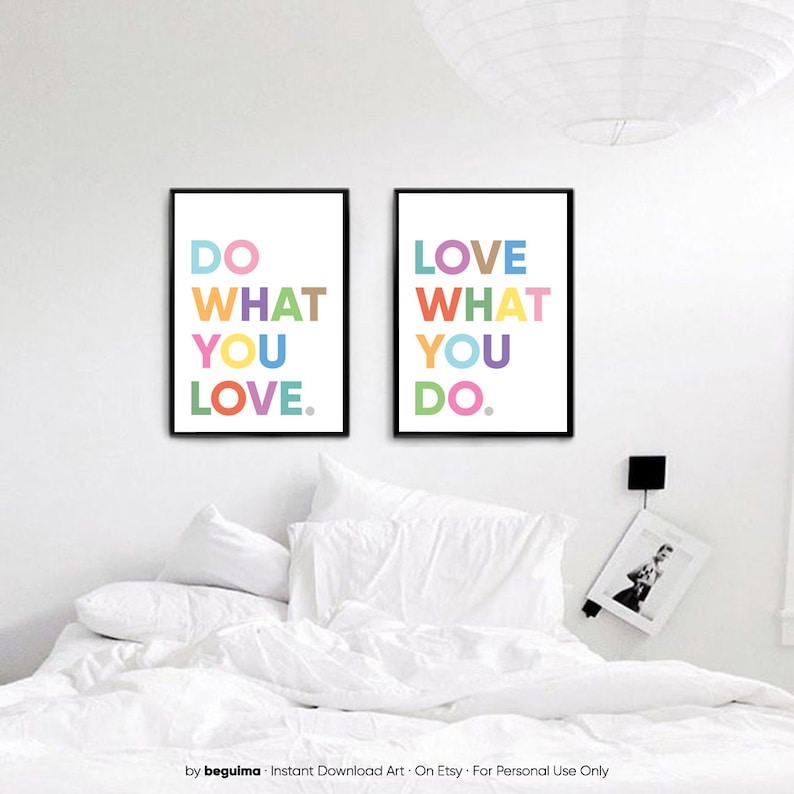 May include: Two framed art prints with black frames and white backgrounds. The left print says "DO WHAT YOU LOVE" in colorful letters. The right print says "LOVE WHAT YOU DO" in colorful letters. The prints are above a bed with white bedding.