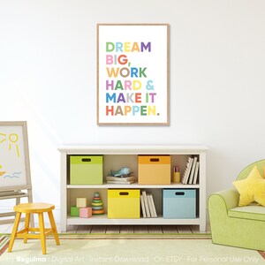 May include: A motivational poster with the text "DREAM BIG, WORK HARD & MAKE IT HAPPEN." in a colorful rainbow font on a white background with a wooden frame.