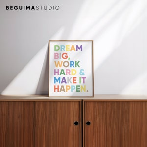May include: A framed motivational poster with the text "DREAM BIG, WORK HARD & MAKE IT HAPPEN." in colorful letters on a white background.