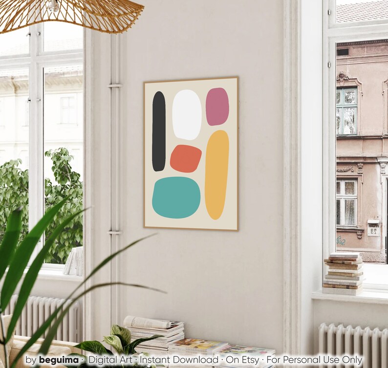May include: A framed abstract art print featuring a beige background with colorful, irregular shapes in black, white, red-orange, teal, yellow, and magenta. The print is displayed in a light-colored wooden frame. The bottom of the image has the text "by beguima - Digital Art - Instant Download - On Etsy - For Personal Use Only."