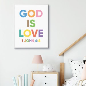 May include: A framed print with the words "GOD IS LOVE" in colorful block letters, with "1 JOHN 4:8" below. The print is displayed above a nightstand with a lamp and cloud-shaped light.