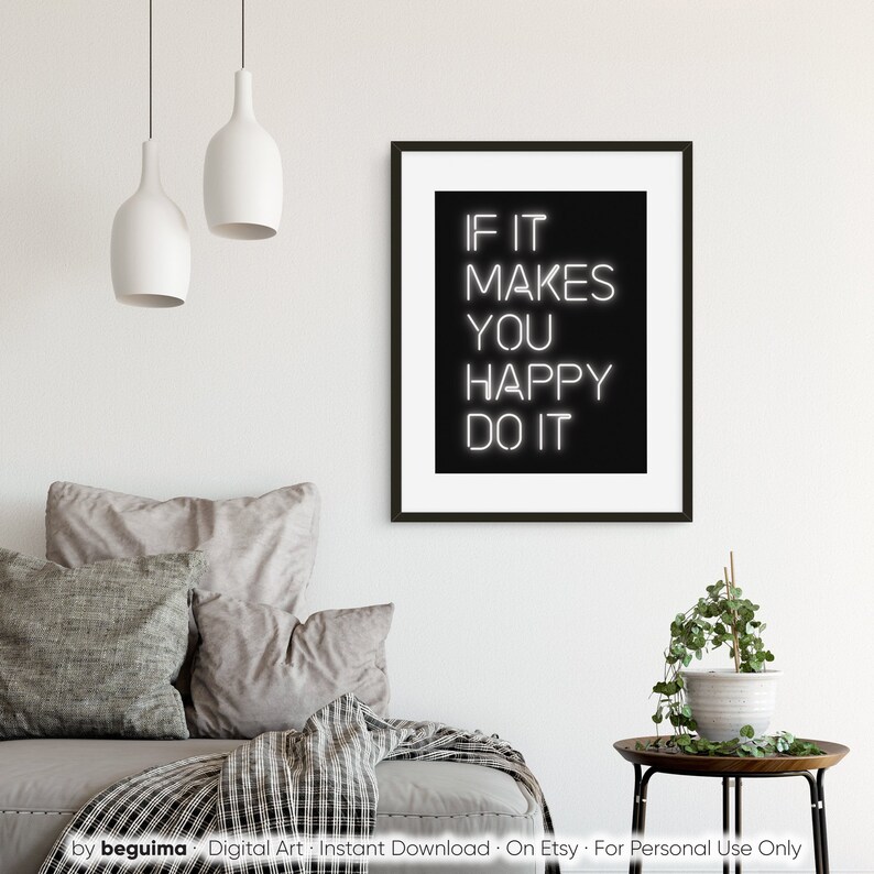 May include: A framed black and white print with the text "IF IT MAKES YOU HAPPY DO IT". The artwork is displayed in a modern living room setting, with neutral-toned pillows and a small side table with a plant.
