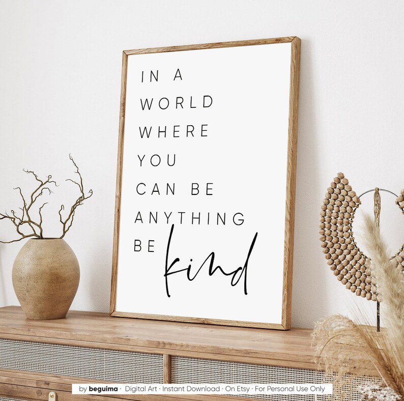 May include: A white framed print with black text that reads "In a world where you can be anything be kind".