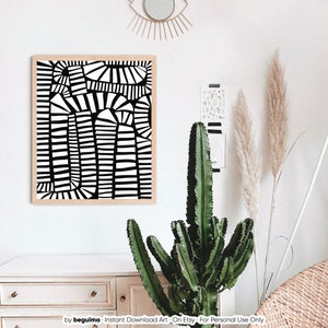May include: A framed black and white abstract art print with geometric shapes. The artwork features a series of vertical and arched lines, creating a bold contrast. The print is displayed on a white wall, complemented by a cactus and decorative elements.