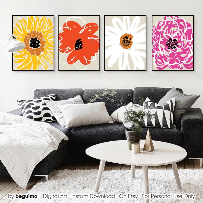 May include: Four framed floral art prints. Each print features a different flower design in vibrant colors: yellow, red, white, and pink. The flowers have black and brown centers and are set against a neutral background. The prints are displayed above a gray sofa.