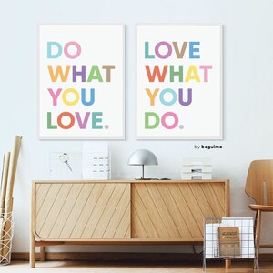 May include: Two framed art prints with the phrases "DO WHAT YOU LOVE" and "LOVE WHAT YOU DO" in colorful block letters. The prints are displayed above a wooden cabinet with a silver lamp and a wire magazine rack.