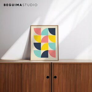 Puede incluir: Una impresi&oacute;n art&iacute;stica enmarcada con un dise&ntilde;o geom&eacute;trico de semic&iacute;rculos en rosa, amarillo, turquesa y azul marino. La impresi&oacute;n se muestra en un mueble de madera. El texto "BEGUIMA STUDIO" est&aacute; en la parte superior.