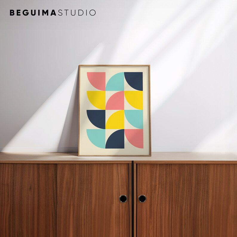 Puede incluir: Una impresi&oacute;n art&iacute;stica enmarcada con un dise&ntilde;o geom&eacute;trico de semic&iacute;rculos en rosa, amarillo, turquesa y azul marino. La impresi&oacute;n se muestra en un mueble de madera. El texto "BEGUIMA STUDIO" est&aacute; en la parte superior.