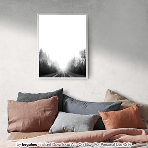 May include: Black and white framed print of a road disappearing into a foggy forest. The artwork is displayed above a bed with various colored pillows and a pink comforter. The print is labeled "Instant Download Art - On Etsy - For Personal Use Only".