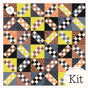 May include: A quilt kit featuring a patchwork design with various Halloween-themed fabrics. The fabrics include black, white, orange, yellow, brown, and gray patterns. The kit includes the word "Kit" in a white circle with a distressed texture.