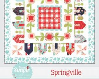 May include: A quilt pattern called "Springville" from the "Thimble Blossoms" collection by Camille Roskelley. The pattern features a red and white gingham center surrounded by a border of houses, flowers, and leaves. The quilt pattern is number 222.