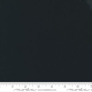 May include: A solid black fabric with a ruler along the bottom edge. The ruler is marked in inches and has the Moda Fabrics logo and website address printed on it.