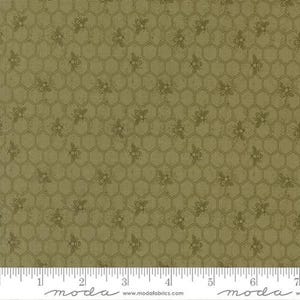 May include: Olive green fabric with a repeating pattern of bees and honeycomb. The bees are a darker shade of green, and the honeycomb pattern is visible throughout the fabric. A ruler is at the bottom of the image.