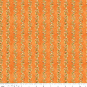 May include: Orange fabric with a repeating pattern of small white flowers in rows. The fabric is 12 inches wide and has a ruler marked in inches along the bottom.