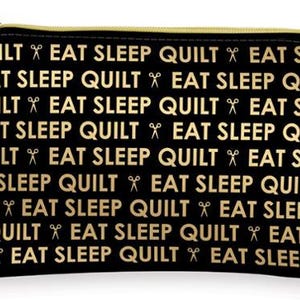 May include: Black zippered pouch with a gold zipper and a repeating pattern of the text "QUILT EAT SLEEP" with gold scissors in between each phrase.