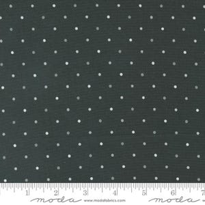 May include: A dark gray fabric with a white polka dot pattern. The fabric is shown with a ruler for scale.