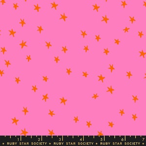 May include: Bright pink fabric with a scattered pattern of orange stars. The stars are hand-drawn in a playful style. The fabric has a ruler along the bottom with the text "RUBY STAR SOCIETY".
