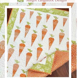 May include: A quilt pattern featuring a white background with orange carrot shapes. The quilt is surrounded by a green and white border. The quilt is folded in half and the bottom half is visible. The quilt is on a wooden surface. The text "Carrot Patch" and "www.thepatternbasket.com" is visible at the bottom of the image.