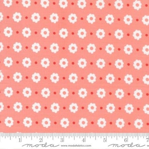 May include: A pink fabric with a repeating pattern of white flowers and red dots.