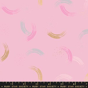 May include: Pink fabric with a repeating pattern of gold, pink, and blue brushstrokes in the shape of arcs. The fabric has a subtle sparkle.