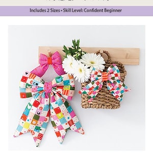 May include: Mini patchwork quilted bows pattern featuring text that reads MINI PATCHWORK QUILTED BOWS, Includes 2 Sizes, Skill Level: Confident Beginner. The image displays three fabric bows in pink, multi-colored checkered patterns, and a woven basket.