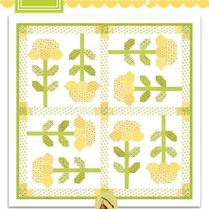 May include: A quilting pattern for a mini quilt called "Buttercups" by Fig Tree & Co. by Joanna Figueroa. The pattern features a white background with yellow and green floral designs.