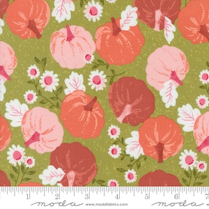 May include: Green fabric with a repeating pattern of pink, orange, and red pumpkins with white flowers and leaves. The fabric has a textured, slightly distressed look. The text "moda" is printed on the bottom of the fabric.