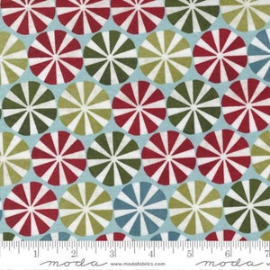 May include: A blue fabric with a repeating pattern of white, red, and green circles with a radiating design. The circles are arranged in a staggered pattern.