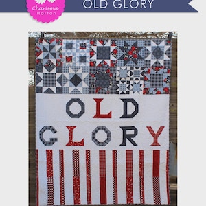May include: A patriotic quilt with the words "OLD GLORY" in red and navy blue. The quilt features a patchwork design with stars and stripes, measuring 60" x 72". The top section has a variety of geometric patterns in red, white, and blue.