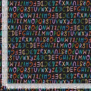 May include: A black fabric featuring a repeating pattern of multicolored handwritten-style alphabet letters in orange, pink, blue, and green. A ruler along the left and bottom edges shows a scale of 11 inches, indicating the print layout.