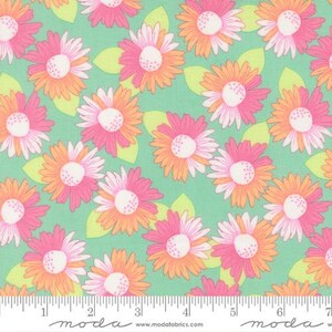 May include: A cotton fabric featuring a repeating pattern of stylized flowers with pink and orange petals and white centers, interspersed with light green leaves on a mint green background, shown next to a ruler measuring 7 inches.