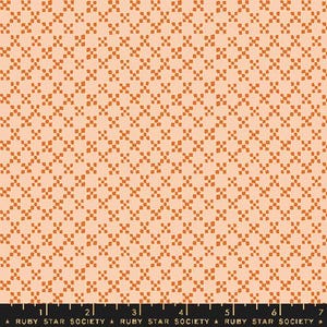 May include: Peach-colored fabric with a repeating pattern of rust-colored cross-like shapes. The fabric has a subtle texture and a grid-like arrangement of the design. The words "RUBY STAR SOCIETY" are printed at the bottom of the fabric.