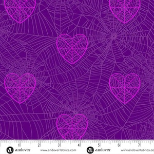 May include: A purple fabric with a repeating pattern of pink heart-shaped spiderwebs. The spiderwebs are outlined in pink and have a detailed web design. The fabric has a ruler along the bottom with the Andover Fabrics logo.