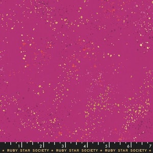May include: A magenta fabric with a speckled pattern of gold, orange, and purple dots. The fabric has a smooth texture and is suitable for various sewing projects. The text "RUBY STAR SOCIETY" is printed at the bottom.