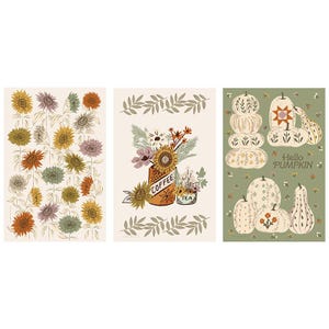 May include: Three rectangular prints featuring seasonal illustrations. The left print shows sunflowers in yellow, orange, and muted green. The center print displays flowers in a mug labeled COFFEE and TEA. The right print shows pumpkins with the text Hello PUMPKIN.