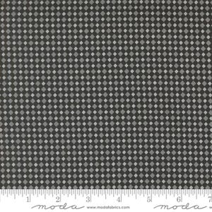 May include: Close-up of a fabric with a repeating diamond pattern in shades of gray and black. The fabric has a ruler along the bottom edge with the word "moda" and the website address "www.modafabrics.com" printed on it.