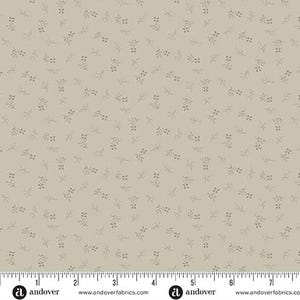 May include: A beige fabric with a repeating pattern of small, gray sprigs. The fabric is measured with a ruler in inches. The text "andover" appears on the ruler.